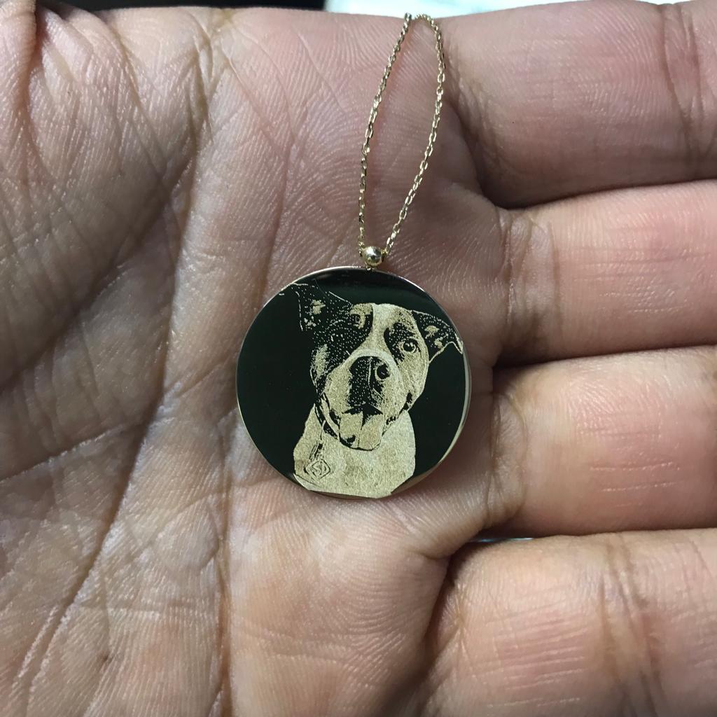 A pet photo necklace displayed on a jewelry stand, featuring a pendant designed to hold a small photograph of a beloved pet, surrounded by intricate detailing